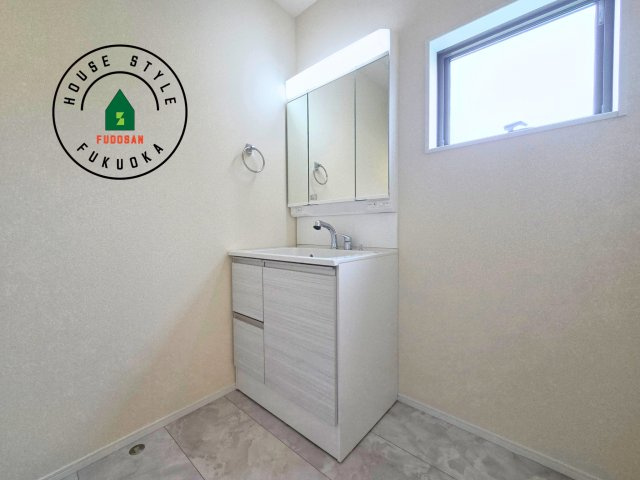 糸島市志摩サンセットロード第1-1棟（1号棟）の独立洗面台|毎日使うものだから清潔な空間を保ちたい水回り。洗面にはそんな願いを解消させてくれる収納アイデアが満載です。三面鏡の裏側にはキャビネットが現れ小物から背の高い物まで収納できます。