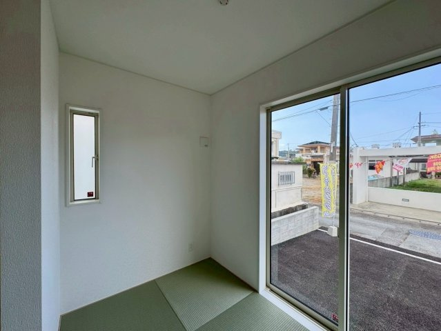 クレイドルガーデンうるま市石川 第７・２号棟の和室|リビングに隣接したタタミコーナー３帖／駐車場から出入りできる掃き出し窓付き