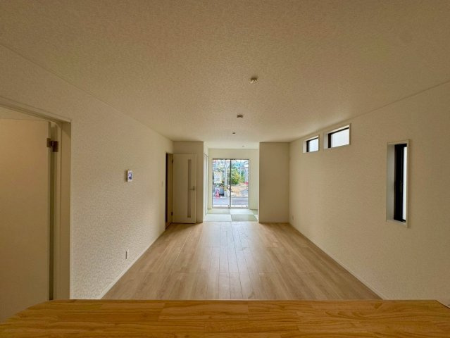 クレイドルガーデンうるま市石川 第７・４号棟の居間・リビング|対面式キッチンからリビングの眺め