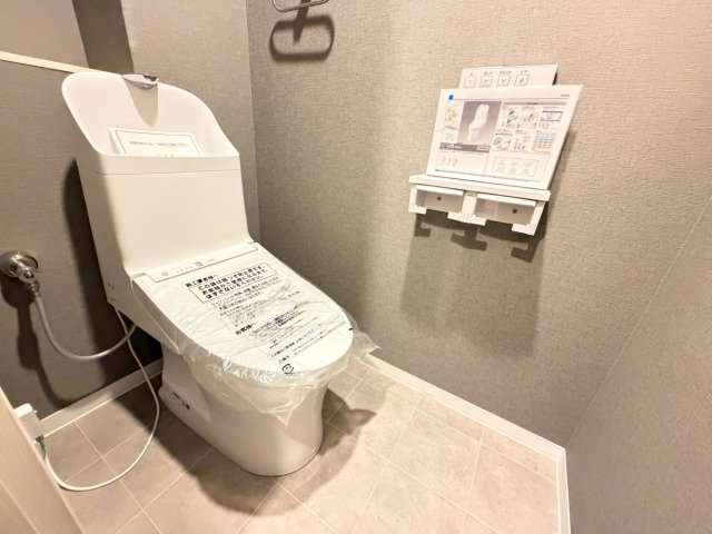 【トイレ】 | 【新規リフォーム】エイシティヒルズアリーナⅢ番館 | TOT社製シャワートイレ。クリーン便座、トルネード洗浄、暖房便座などの機能を備えています！　側面にはブルーグレーのアクセントクロスを貼って仕上げました。