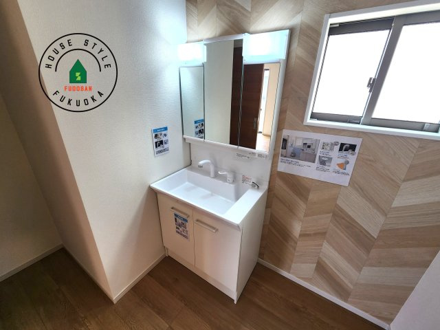 福岡市城南区友丘4丁目第1-3棟（2号棟）の内観：施工例|毎日使うものだから清潔な空間を保ちたい水回り。洗面にはそんな願いを解消させてくれる収納アイデアが満載です。三面鏡の裏側にはキャビネットが現れ小物から背の高い物まで収納できます。