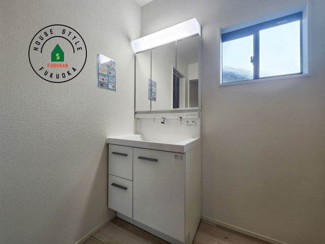 福岡市南区若久6丁目第9-2棟（2号棟）の内観：施工例|毎日使うものだから清潔な空間を保ちたい水回り。洗面にはそんな願いを解消させてくれる収納アイデアが満載です。三面鏡の裏側にはキャビネットが現れ小物から背の高い物まで収納できます。