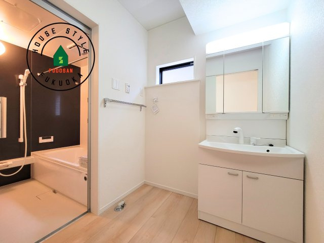 福岡市南区曰佐3丁目第2-3棟（2号棟）の脱衣所|ゆとりの洗面スペースで朝の身支度もスムーズに。暮らしを快適に変えるシャワー付洗面台です！