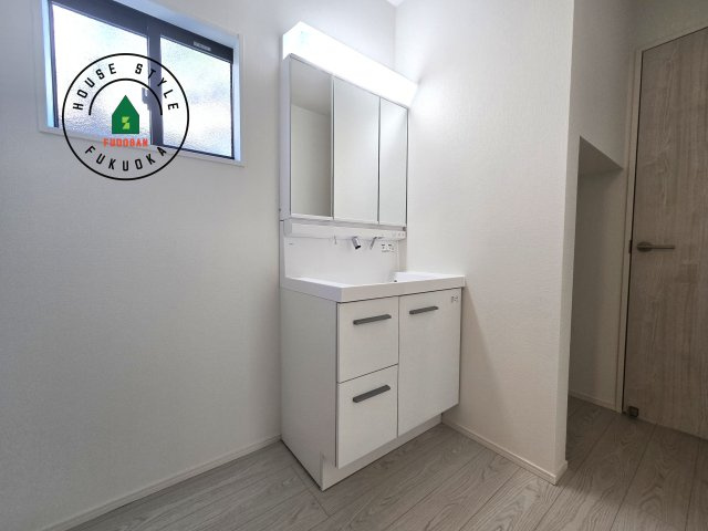 福津市津屋崎8丁目第1-3棟(3号棟）の内観：施工例|毎日使うものだから清潔な空間を保ちたい水回り。洗面にはそんな願いを解消させてくれる収納アイデアが満載です。三面鏡の裏側にはキャビネットが現れ小物から背の高い物まで収納できます。