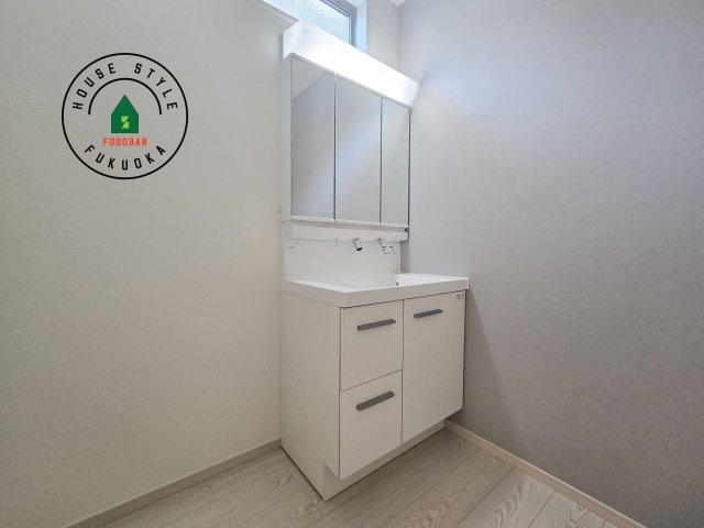 福岡市南区皿山4丁目第3-2棟（2号棟）の内観：施工例|毎日使うものだから清潔な空間を保ちたい水回り。洗面にはそんな願いを解消させてくれる収納アイデアが満載です。三面鏡の裏側にはキャビネットが現れ小物から背の高い物まで収納できます。