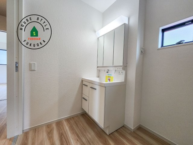 古賀市花見東3丁目第3-2棟（2号棟）　の独立洗面台|毎日使うものだから清潔な空間を保ちたい水回り。洗面にはそんな願いを解消させてくれる収納アイデアが満載です。三面鏡の裏側にはキャビネットが現れ小物から背の高い物まで収納できます。