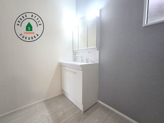 福津市福間南5丁目第6-2棟（1号棟）の内観：施工例|毎日使うものだから清潔な空間を保ちたい水回り。洗面にはそんな願いを解消させてくれる収納アイデアが満載です。三面鏡の裏側にはキャビネットが現れ小物から背の高い物まで収納できます。