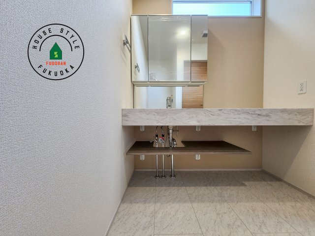 大野城市つつじヶ丘3丁目第1-2棟（1号棟）の独立洗面台|毎日使うものだから清潔な空間を保ちたい水回り。洗面にはそんな願いを解消させてくれる収納アイデアが満載です。三面鏡の裏側にはキャビネットが現れ小物から背の高い物まで収納できます。