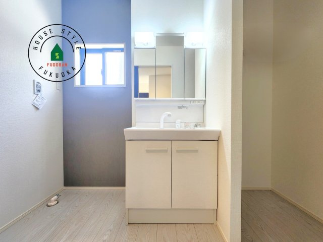 福津市津屋崎1丁目第5-2棟（1号棟）の内観：施工例|毎日使うものだから清潔な空間を保ちたい水回り。洗面にはそんな願いを解消させてくれる収納アイデアが満載です。三面鏡の裏側にはキャビネットが現れ小物から背の高い物まで収納できます。