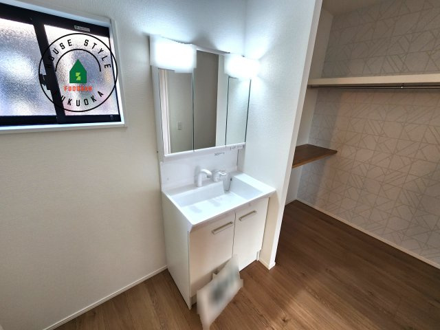 福津市津屋崎1丁目第5-2棟（1号棟）の内観：施工例|毎日使うものだから清潔な空間を保ちたい水回り。洗面にはそんな願いを解消させてくれる収納アイデアが満載です。三面鏡の裏側にはキャビネットが現れ小物から背の高い物まで収納できます。