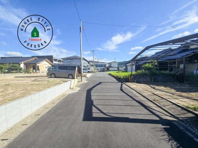 福津市津屋崎1丁目第5-2棟（2号棟）の前面道路含む現地写真|前面道路は閑静な住宅地をはしる車通りの少ない道路。お車の出し入れが苦手なママや小さなお子様にも安心ですね。しっかり舗装もされているので、ベビーカーや自転車で通っても快適に通行できます。