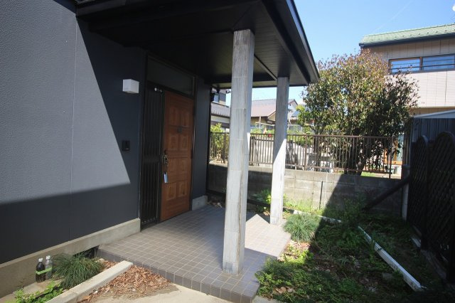 結城市結城　1期の玄関|屋根付きの玄関ポーチで、雨の日でもゆったり出入りしやすい造りです！落ち着いた玄関ドアが外観の雰囲気によく馴染んでいます。