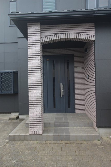 小山市雨ケ谷の玄関|玄関まわりはタイル仕上げで高級感たっぷり！屋根付きポーチなので雨の日も出入りしやすく、落ち着いたデザインの玄関ドアが住まいの印象をグッと引き締めてくれます。