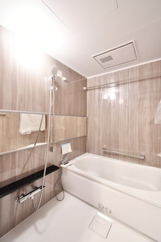 プロムナード大宮春野B-4番館の浴室|シックで上品さを感じるバスルームはまるでホテルのような仕上がり。日常から解放できる癒しの空間となります。木目がアクセントになっております！新品ですのでご入居後から気持ちよく入浴頂けます。