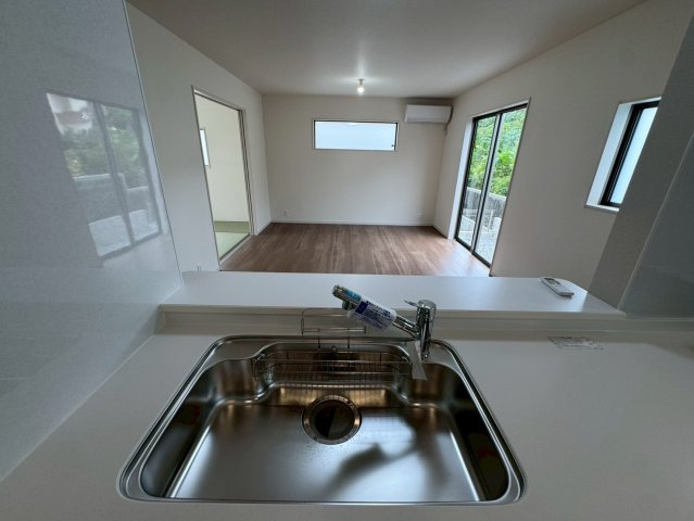 リーブルガーデン八重瀬町具志頭・１０号棟のキッチン|浄水器付きキッチンの流し台／ダイニングの眺め