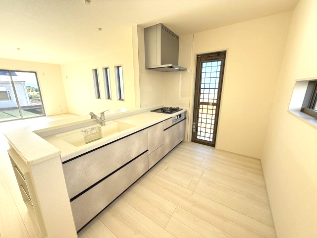 リーブルガーデンＳ第11　前橋市富士見町時沢　２号棟のキッチン|人気のカウンターキッチン採用です☆ゴミ出しに便利な勝手口付き！
コンロも３口ご用意しています！調理スペースも広くストレスなくお料理できます。
浄水器つきなので美味しいお水も飲めますよ♪