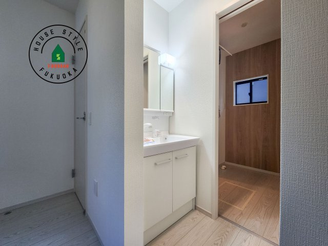 東区奈多2丁目第5-5棟（4号棟）の内観：施工例|毎日使うものだから清潔な空間を保ちたい水回り。洗面にはそんな願いを解消させてくれる収納アイデアが満載です。三面鏡の裏側にはキャビネットが現れ小物から背の高い物まで収納できます。