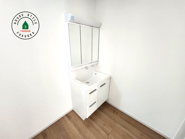 福岡市東区奈多1丁目第2-6棟（1号棟）の内観：施工例|毎日使うものだから清潔な空間を保ちたい水回り。洗面にはそんな願いを解消させてくれる収納アイデアが満載です。三面鏡の裏側にはキャビネットが現れ小物から背の高い物まで収納できます。