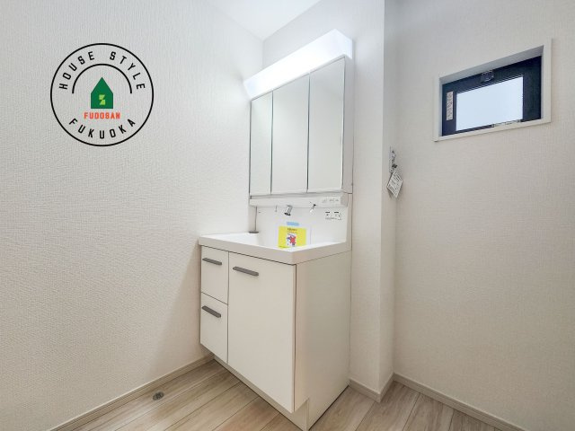 大野城市中央１丁目第1-3棟（2号棟）の内観：施工例|毎日使うものだから清潔な空間を保ちたい水回り。洗面にはそんな願いを解消させてくれる収納アイデアが満載です。三面鏡の裏側にはキャビネットが現れ小物から背の高い物まで収納できます。