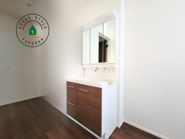 福岡市東区奈多1丁目第2-6棟（6号棟）の内観：施工例|毎日使うものだから清潔な空間を保ちたい水回り。洗面にはそんな願いを解消させてくれる収納アイデアが満載です。三面鏡の裏側にはキャビネットが現れ小物から背の高い物まで収納できます。