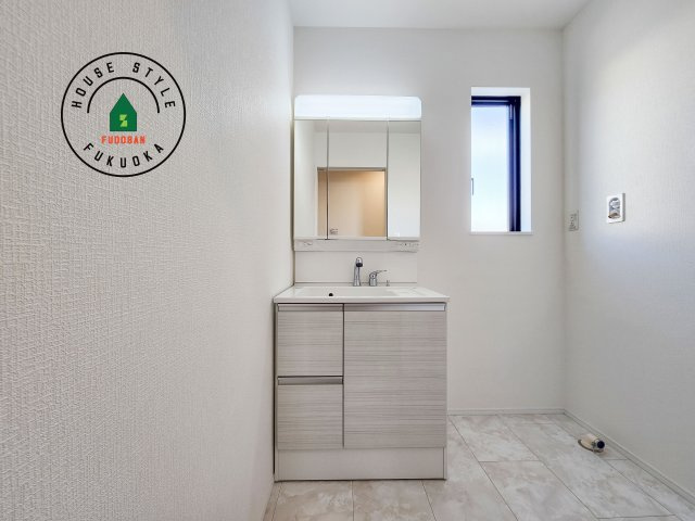 福岡市西区泉3丁目第1-2棟（A号棟)の内観：施工例|毎日使うものだから清潔な空間を保ちたい水回り。洗面にはそんな願いを解消させてくれる収納アイデアが満載です。三面鏡の裏側にはキャビネットが現れ小物から背の高い物まで収納できます。