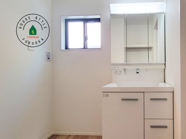 福岡市東区奈多1丁目第2-6棟（1号棟）の内観：施工例|毎日使うものだから清潔な空間を保ちたい水回り。洗面にはそんな願いを解消させてくれる収納アイデアが満載です。三面鏡の裏側にはキャビネットが現れ小物から背の高い物まで収納できます。