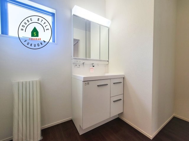 福岡市東区奈多1丁目第2-6棟（2号棟）の内観：施工例|毎日使うものだから清潔な空間を保ちたい水回り。洗面にはそんな願いを解消させてくれる収納アイデアが満載です。三面鏡の裏側にはキャビネットが現れ小物から背の高い物まで収納できます。