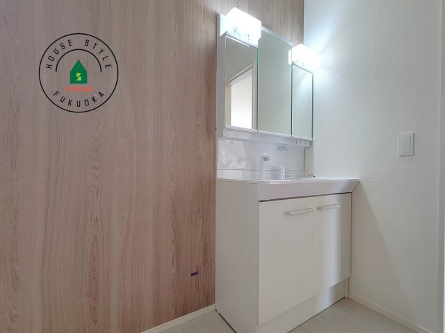 福岡市東区奈多1丁目第2-6棟（4号棟）の内観：施工例|毎日使うものだから清潔な空間を保ちたい水回り。洗面にはそんな願いを解消させてくれる収納アイデアが満載です。三面鏡の裏側にはキャビネットが現れ小物から背の高い物まで収納できます。