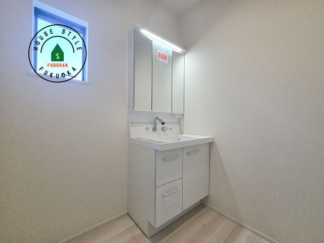 小郡市寺福童第1-2棟（2号棟）の内観：施工例|毎日使うものだから清潔な空間を保ちたい水回り。洗面にはそんな願いを解消させてくれる収納アイデアが満載です。三面鏡の裏側にはキャビネットが現れ小物から背の高い物まで収納できます。