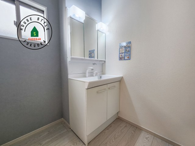 春日市春日10丁目第1-4棟（1号棟）の独立洗面台|毎日使うものだから清潔な空間を保ちたい水回り。洗面にはそんな願いを解消させてくれる収納アイデアが満載です。三面鏡の裏側にはキャビネットが現れ小物から背の高い物まで収納できます。