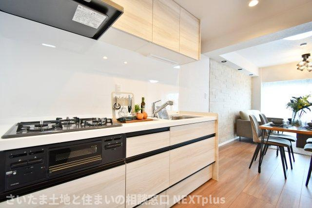 ドルミ春日部のキッチン|白基調の吊戸棚付きシステムキッチンです。上にも下にもたくさん収納出来ますので、別途で食器棚がなくてもたくさん収納する事ができます！ライトもありますので、お料理中の手元もしっかり照らしてくれます。