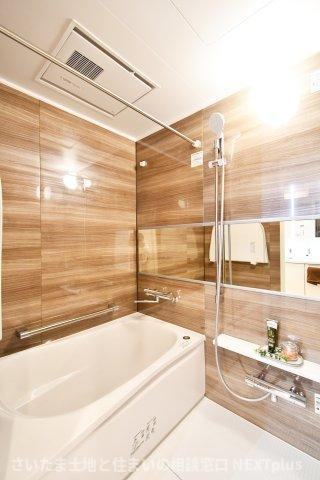 ドルミ春日部の浴室|シックで上品さを感じるバスルームはまるでホテルのような仕上がり。日常から解放できる癒しの空間となります。木目がアクセントになっております！新品ですのでご入居後から気持ちよく入浴頂けます。