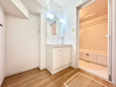 【洗面所】 | 伏見区桃山与五郎町　新築戸建 | 白を基調とした清潔感のある洗面です。洗面台は三面鏡タイプになっているので、鏡裏にも小物を収納できるので、水回りがスッキリとします。