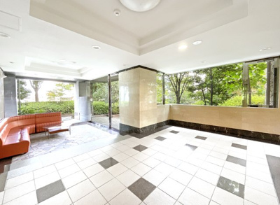 【エントランス】 | サーパス山科小野 | エントランスにはロビーソファーがあり、待ち合わせ場所としても。開放的なガラス窓の外にはマンションの共有庭。緑豊富で自然も感じられるマンションです。