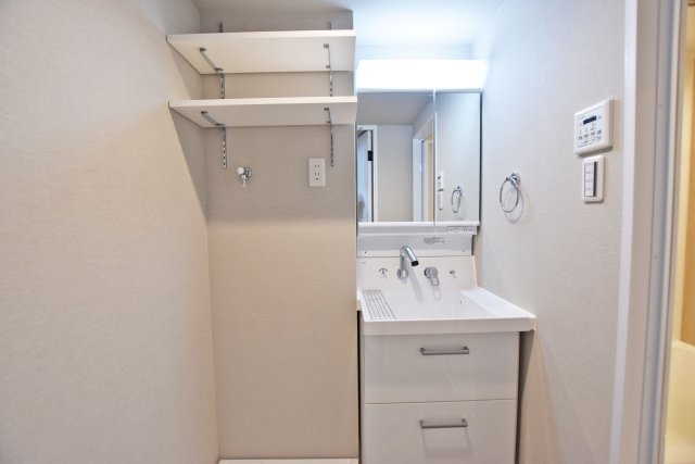 グリーンコーポ江坂第3の独立洗面台|洗面化粧台の横にはタオルや洗濯物を置いて置ける可動棚収納があり便利です。