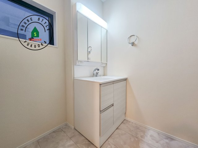 福岡市東区若宮4丁目第3-5棟（1号棟）の内観：施工例|毎日使うものだから清潔な空間を保ちたい水回り。洗面にはそんな願いを解消させてくれる収納アイデアが満載です。三面鏡の裏側にはキャビネットが現れ小物から背の高い物まで収納できます。
