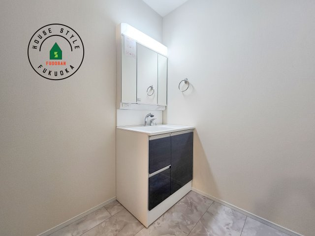 福岡市東区若宮4丁目第3-5棟（2号棟）の内観：施工例|毎日使うものだから清潔な空間を保ちたい水回り。洗面にはそんな願いを解消させてくれる収納アイデアが満載です。三面鏡の裏側にはキャビネットが現れ小物から背の高い物まで収納できます。