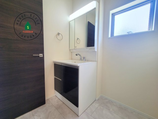 福岡市西区今津第1-1棟（1号棟）の独立洗面台|毎日使うものだから清潔な空間を保ちたい水回り。洗面にはそんな願いを解消させてくれる収納アイデアが満載です。三面鏡の裏側にはキャビネットが現れ小物から背の高い物まで収納できます。