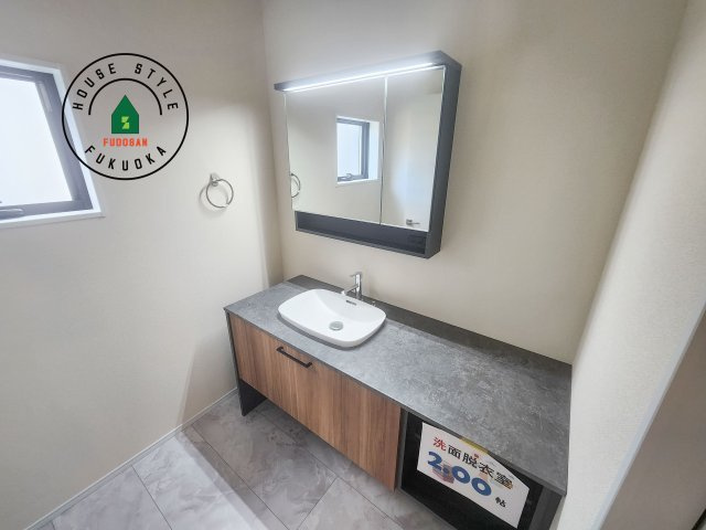 那珂川市後野1丁目第2-2棟（2号棟）の内観：施工例|毎日使うものだから清潔な空間を保ちたい水回り。洗面にはそんな願いを解消させてくれる収納アイデアが満載です。三面鏡の裏側にはキャビネットが現れ小物から背の高い物まで収納できます。