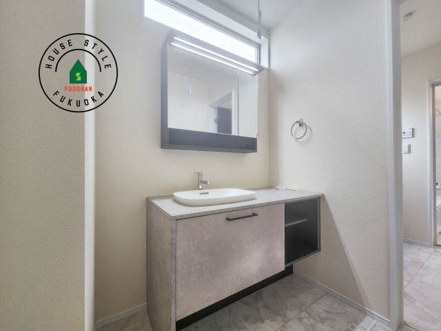 糟屋郡新宮町夜臼2丁目第1-4棟（2号棟）の内観：施工例|毎日使うものだから清潔な空間を保ちたい水回り。洗面にはそんな願いを解消させてくれる収納アイデアが満載です。三面鏡の裏側にはキャビネットが現れ小物から背の高い物まで収納できます。