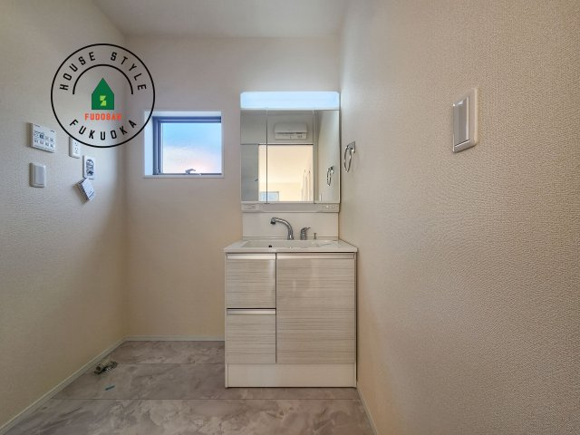 小郡市寺福童第1-3棟（3号棟）の内観：施工例|毎日使うものだから清潔な空間を保ちたい水回り。洗面にはそんな願いを解消させてくれる収納アイデアが満載です。三面鏡の裏側にはキャビネットが現れ小物から背の高い物まで収納できます。