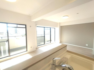 【居間・リビング】 | グラン・ドムール北野田 | 南東面に大きな掃き出し窓を設置。キッチンまでたっぷりと暖かい陽光が差し込みます！対面式キッチンを採用し、調理中でも会話が弾みそうですね。