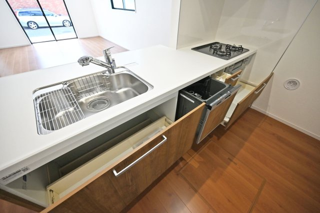 テラシエ池尻新築3丁目一戸建て│4LDK+並列駐車2台可(車種制限有)丁目のキッチン|キッチン天板下いっぱいに収納庫を設けてあります。シンクした収納庫にはナイフホルダーも標準搭載。食器洗い乾燥機や浄水器一体型水栓も標準仕様のユニットが導入されています。