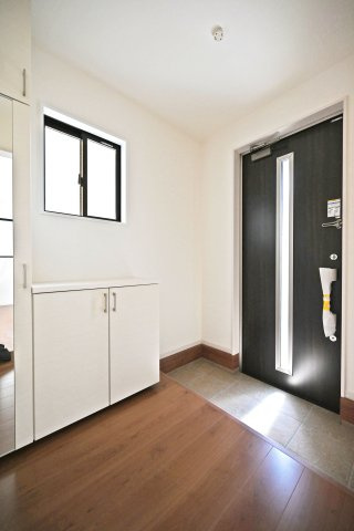 テラシエ池尻新築3丁目一戸建て│4LDK+並列駐車2台可(車種制限有)丁目の玄関|1階玄関をホール側から撮影した内観写真です。 シンプルな玄関扉にシューズボックス、小窓を配置したオーソドックスな玄関です。