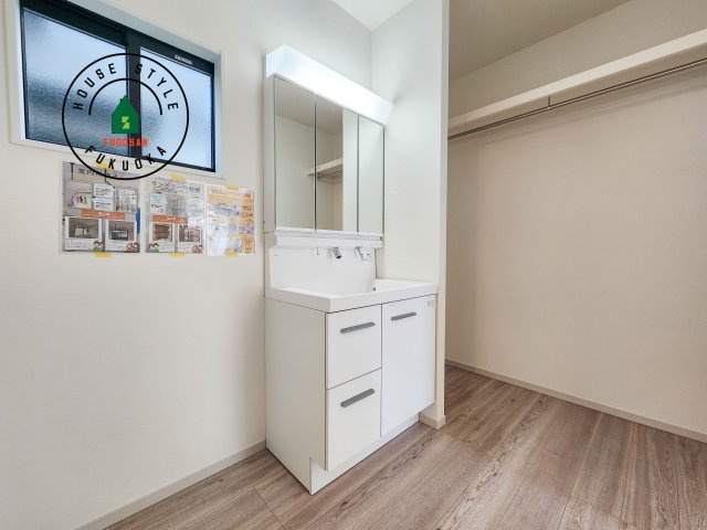 春日市須玖南3丁目第1-2棟（1号棟）の独立洗面台|毎日使うものだから清潔な空間を保ちたい水回り。洗面にはそんな願いを解消させてくれる収納アイデアが満載です。三面鏡の裏側にはキャビネットが現れ小物から背の高い物まで収納できます。