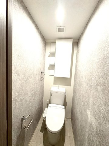 アンビシャスガーデン鶴瀬のトイレ|清潔感のあるトイレです。収納棚付。