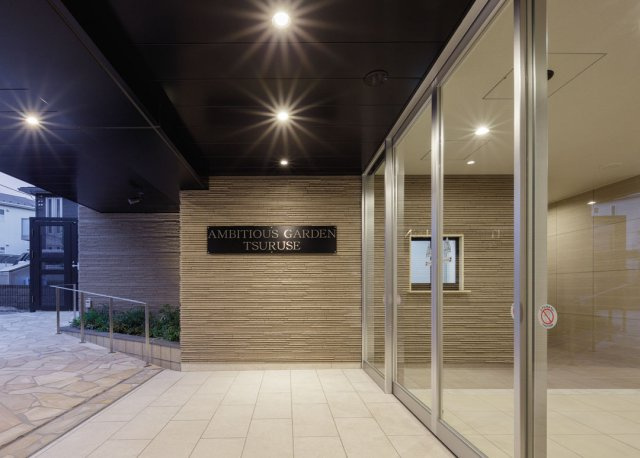 アンビシャスガーデン鶴瀬の外観|マンションの裏側の通路にはコモンガーデンがあり、ベンチも設置しております。