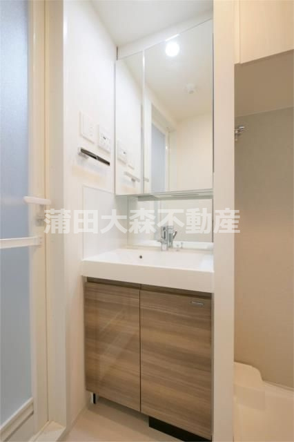 アークマーク大森町アジールコートの洗面所|洗面脱衣所　2面鏡の独立洗面台　棚収納付の洗濯機置き場