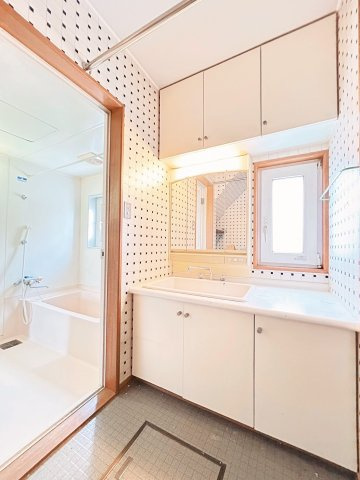 里塚1条3丁目戸建の独立洗面台|洗面スペースは広々とした天板つきの洗面台があり、さまざまな物を設置できるほかアイロンがけの台としても♪収納力のある戸棚や洗濯物を干しておけるポールも完備。