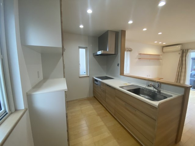 山形市伊達城三丁目17-3　中古住宅のキッチン|白と木目を基調としたデザインで、明るく清潔感があります。広々としたシンクと調理スペース、IHクッキングヒーターも備わっており、料理がしやすいですね。